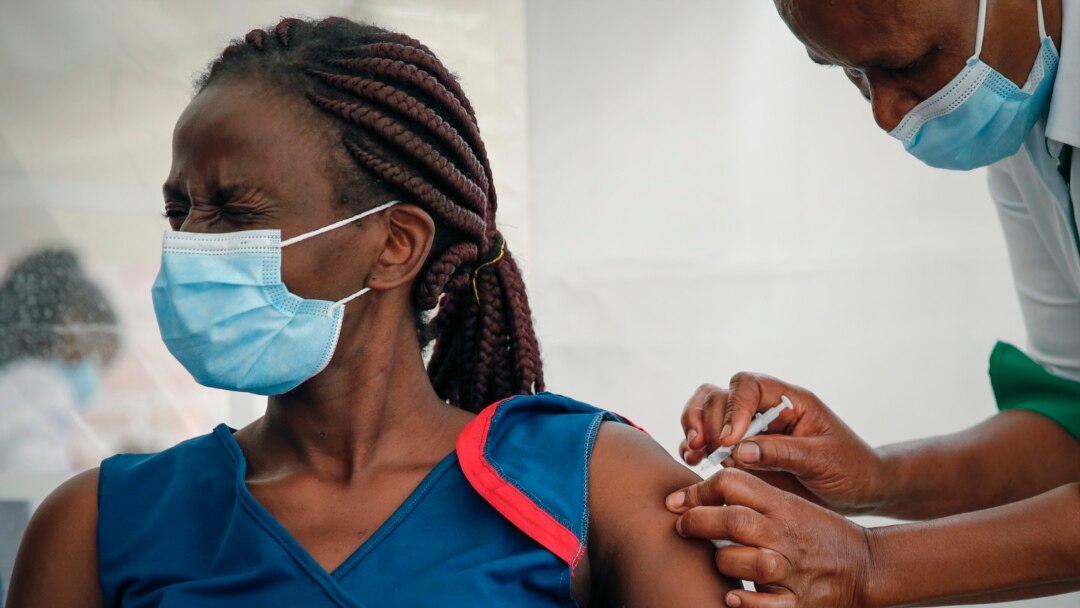 A frontline worker reacrs as she receives a shot of AstraZeneca COVID-19 vaccine, manufactured by the Serum Institute of India and provided through the global COVAX initiative, in Machakos, Kenya, Wednesday, March 24, 2021. (AP Photo/Brian Inganga)