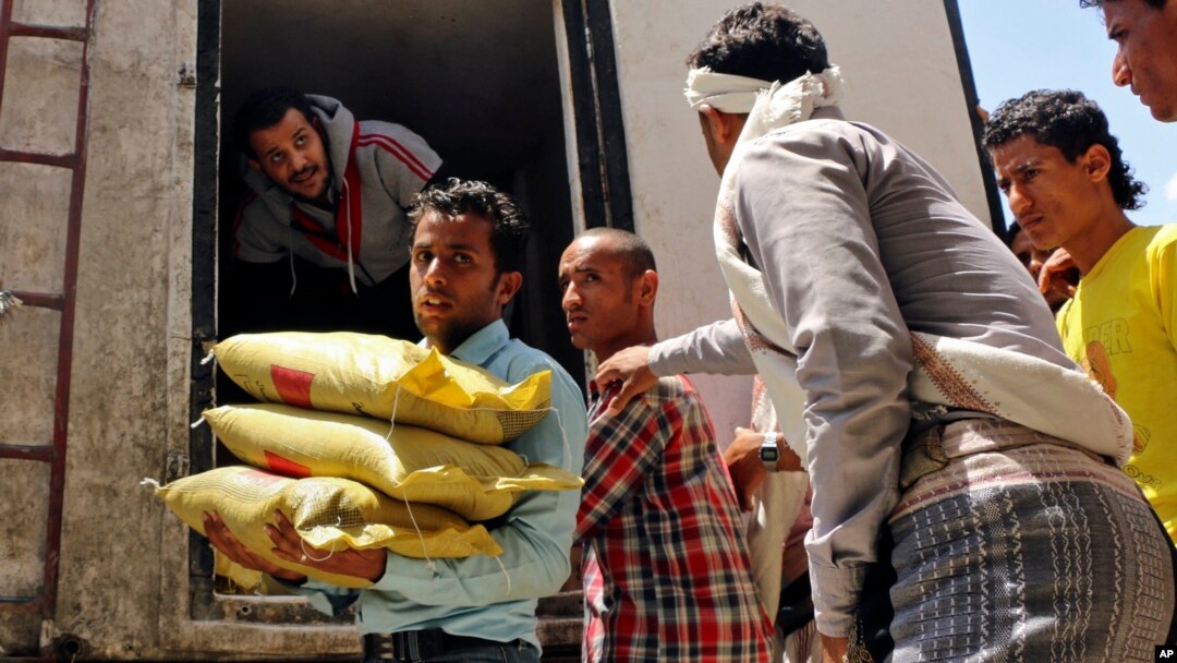 A Yemeni volunteer carries bags of rice to displaced people, who fled fighting in the southern city of Aden, during a food distribution effort in Taiz, Yemen, May 9, 2015.