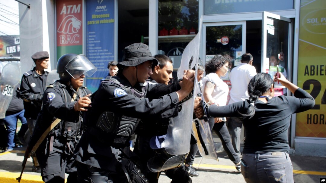 ARCHIVO - Policías antidisturbios desalojan a periodistas desde la entrada principal de su medio hasta una estación de policía en Mangua, Nicaragua, en diciembre del 2018