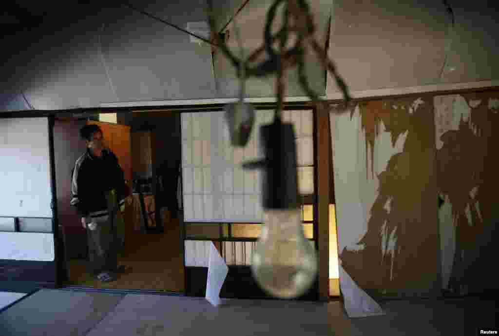 Toshio Koyama, who evacuated from Miyakoji three years ago, looks at a damaged silkworm factory near his house after he returned home with his wife Kimiko, Tamura, Fukushima prefecture, April 1, 2014.