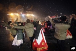 FILE - North Koreans dance on the Kim Il Sung Square to celebrate a satellite launch, Feb. 8, 2016, in Pyongyang, North Korea.