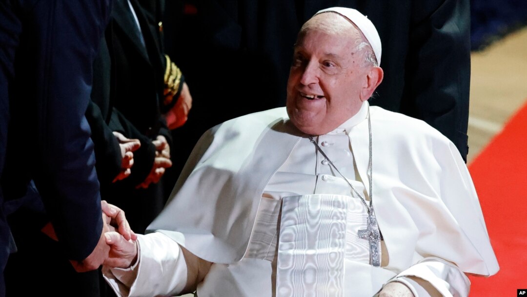 El papa Francisco estrecha la mano de funcionarios después de su reunión para la ceremonia de despedida del Papa en el aeropuerto de Ajaccio, en la isla francesa de Córcega, el 15 de diciembre de 2024.