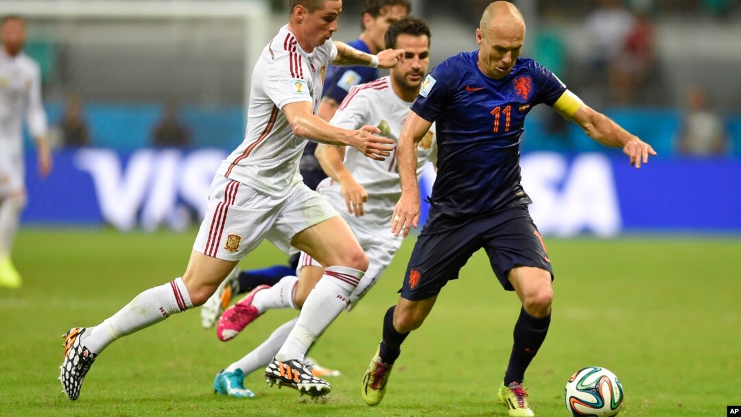 Netherlands' Arjen Robben, right, is challenged by Spain's Fernando Torres during the World Cup match between Spain and the Netherlands, June 13, 2014.
