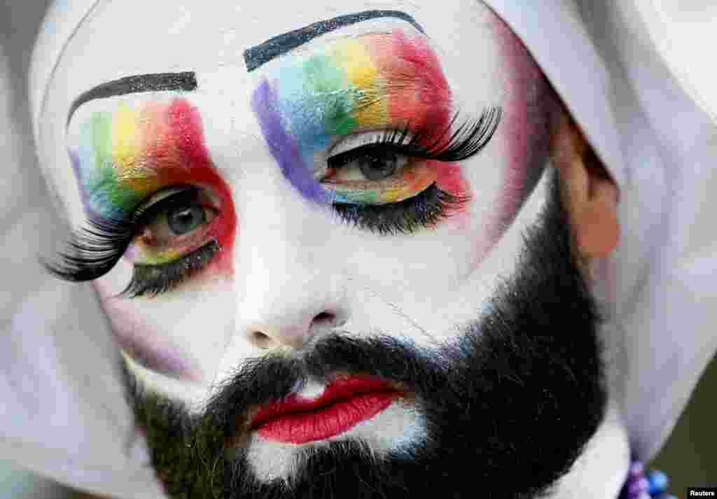 A participant poses while attending the inauguration of the Gay Games village at the Hotel de Ville city hall in Paris, France.