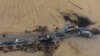An areal picture taken on Oct. 28, 2019, shows vehicles near a destroyed truck at the spot where Abu Hassan al-Muhajir, the Islamic State (IS) group's spokesman, was reportedly killed in a raid in the Syrian village of Ayn al-Bayda near Jarablus.