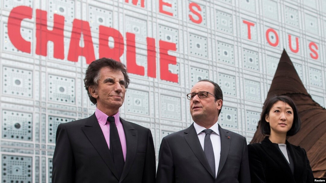 French President Francois Hollande (center) with Culture minister Fleur Pellerin (Right) and the President of the Institut du Monde Arabe (Arab institute), Jack Lang walk near the Arab Institute building in Paris.
