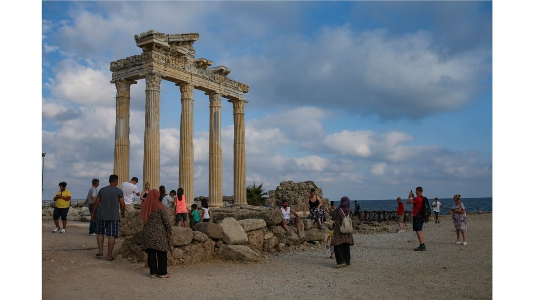 Tourists visit the 150A.D Roman temple dedicated to Apollo the Greek and Roman god of music, harmony and light, in Antalya, southern Turkey, June 20, 2021