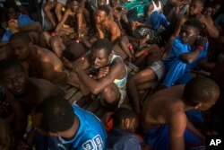 Migrants sit on the deck of the vessel of Proactiva Open Arms after being rescued in the Mediterranean Sea, about 15 miles north of Sabratha, Libya, July 25, 2017. Rights groups say it would be dangerous to try to process asylum-seekers’ requests in Libya..