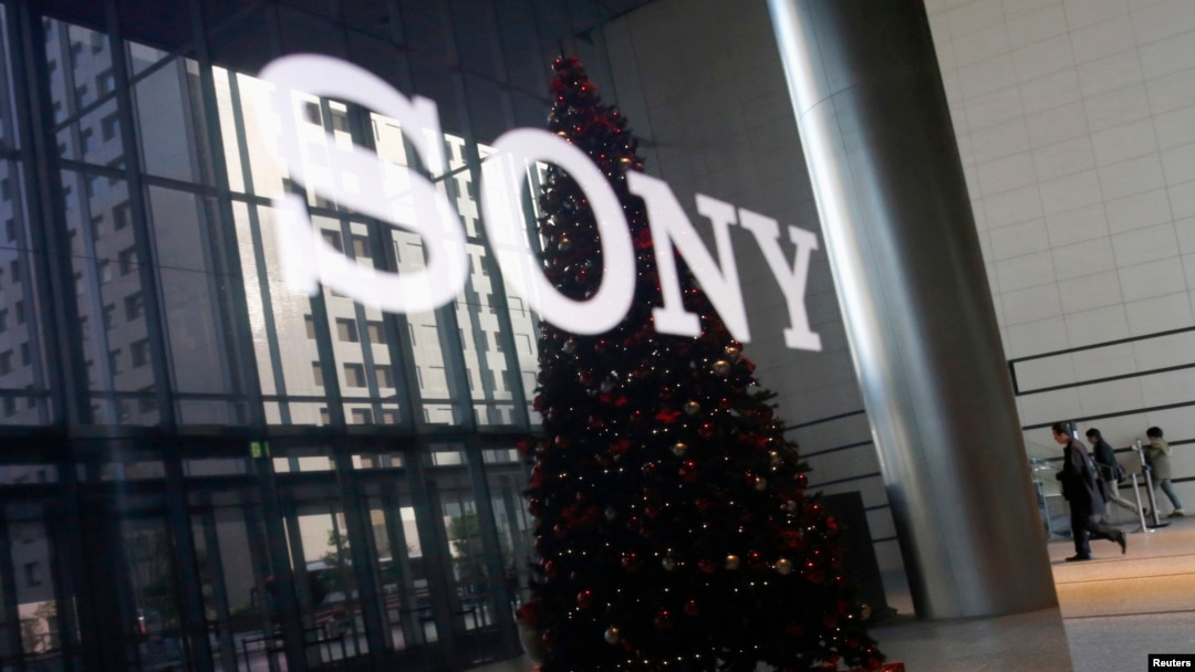 FILE - The logo of Sony Corp and a Christmas tree are reflected on the company's 4K television set at the company's headquarters in Tokyo, Nov. 18, 2014. 