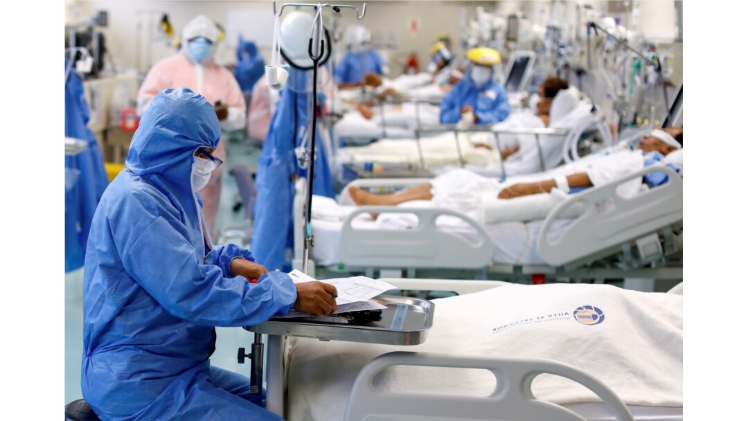 FILE - A medical worker takes notes near a patient at the intensive care unit (ICU) of the Emergencias de Villa El Salvador hospital, during the outbreak of the coronavirus disease (COVID-19), in Lima, Peru, Dec. 22, 2020.
