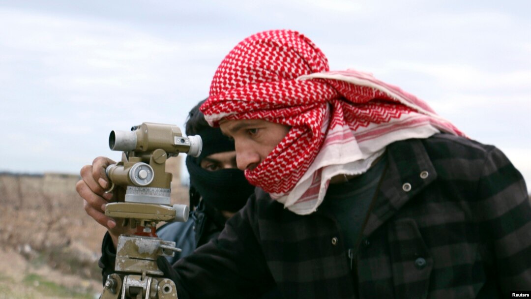 FILE - A Jaish al-Islam (Army of Islam) brigade fighter prepares to launch rockets toward forces loyal to Syria's President Bashar al-Assad located beside Damascus International airport, from the eastern Damascus suburb of Ghouta, Feb. 24, 2015. 