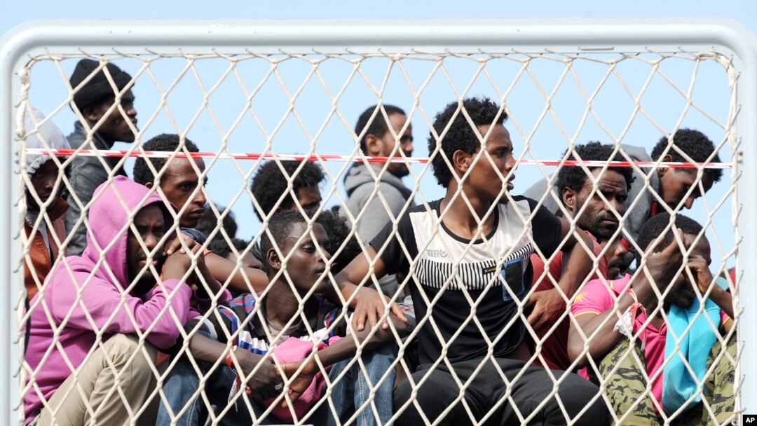 FILE - Migrants wait to disembark from the Italian Navy vessel 'Bettica' in the harbor of Salerno, Italy, May 5, 2015.