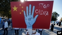 资料照：2020年10月1日，土耳其维吾尔族社区的一名抗议者在伊斯坦布尔市手举写着“停止，中国”的标语牌，抗议中国政府迫害新疆维族人。