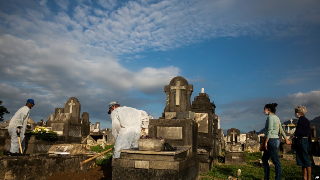 Relatives attend the burial service of 89-year-old Irodina Pinto Ribeiro, who died from complications related to COVID-19, at the Inhauma cemetery in Rio de Janeiro, Brazil, June 18, 2021.