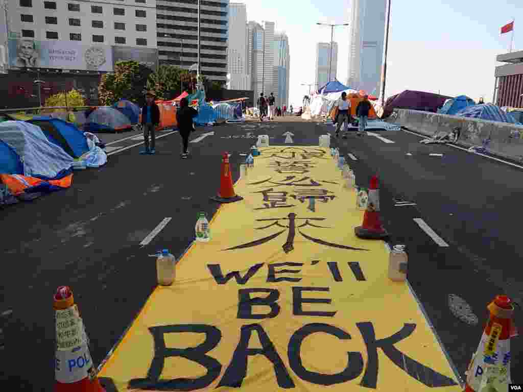 A giant slogan on a flyover in Admiralty, central district of Hong Kong, says "We'll be back," Dec. 9, 2014. (Iris Tong/VOA)