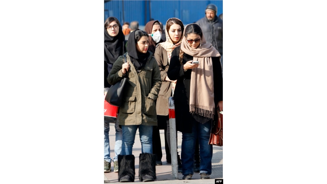 FILE - Iranian women wearing hijabs walk down a street in the capital, Tehran, Feb. 7, 2018.