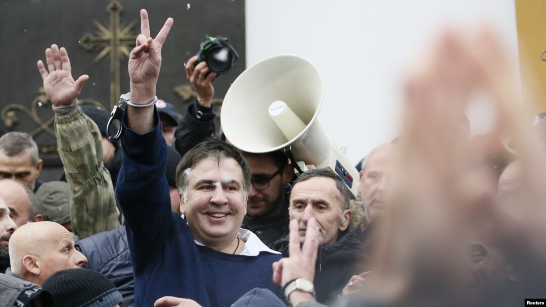 Georgian former President Mikheil Saakashvili flashes a victory sign after he was freed by his supporters in Kyiv, Ukraine, Dec. 5, 2017.