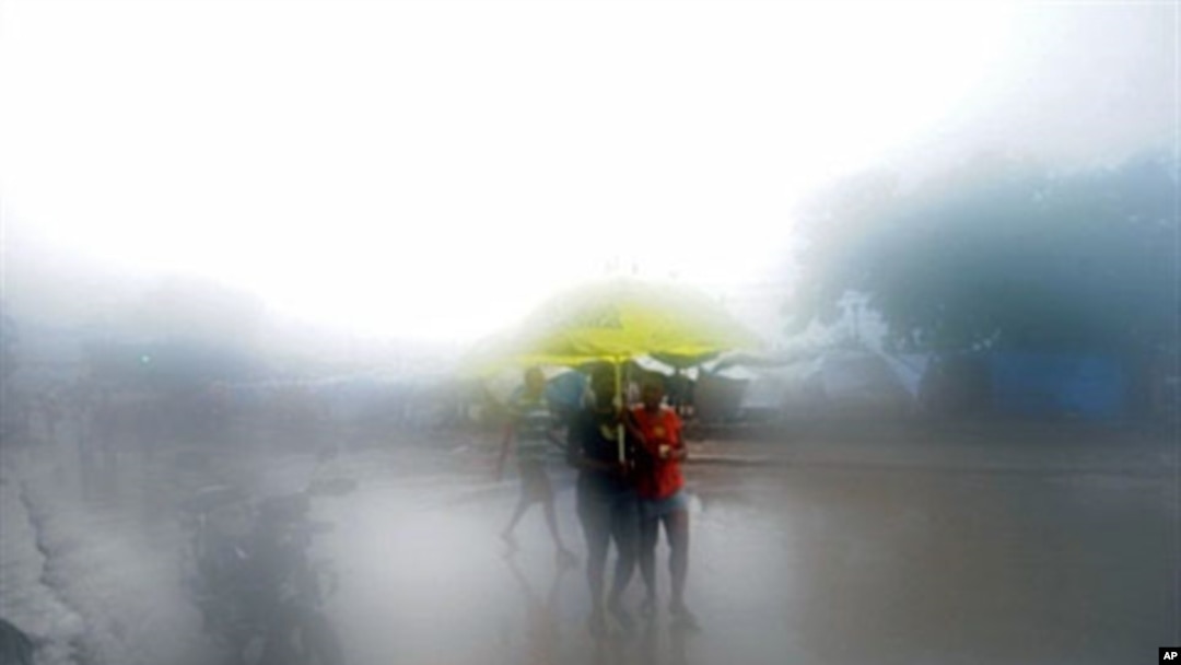People walk in the rain in Port-au-Prince on 05 Nov 2010.