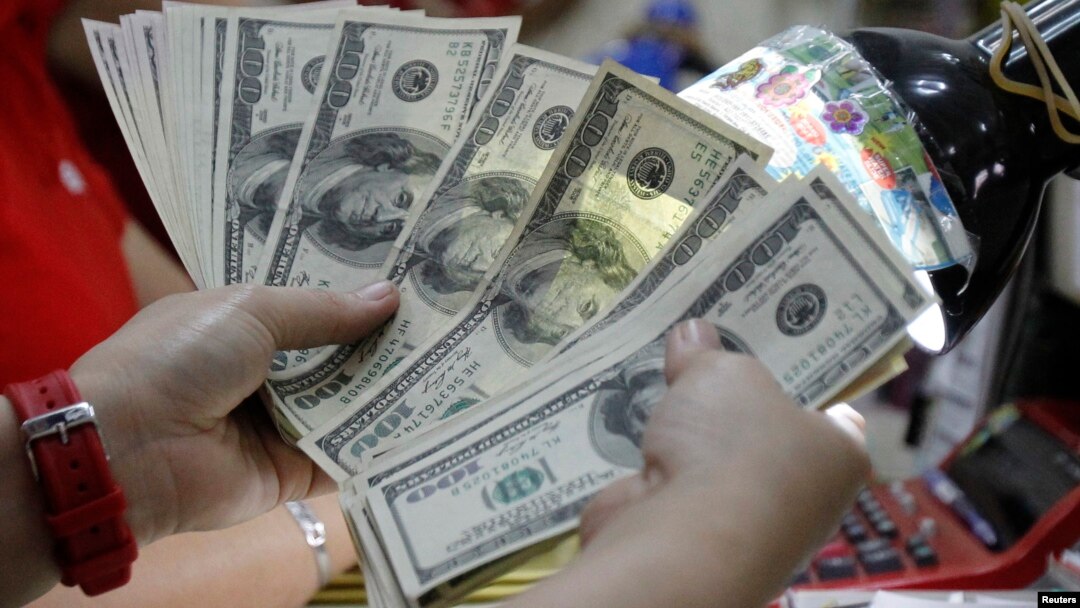 A worker counts U.S. dollar bills, which are being exchanged for Philippine Pesos, inside a money changer in Manila, April 1, 2013. 