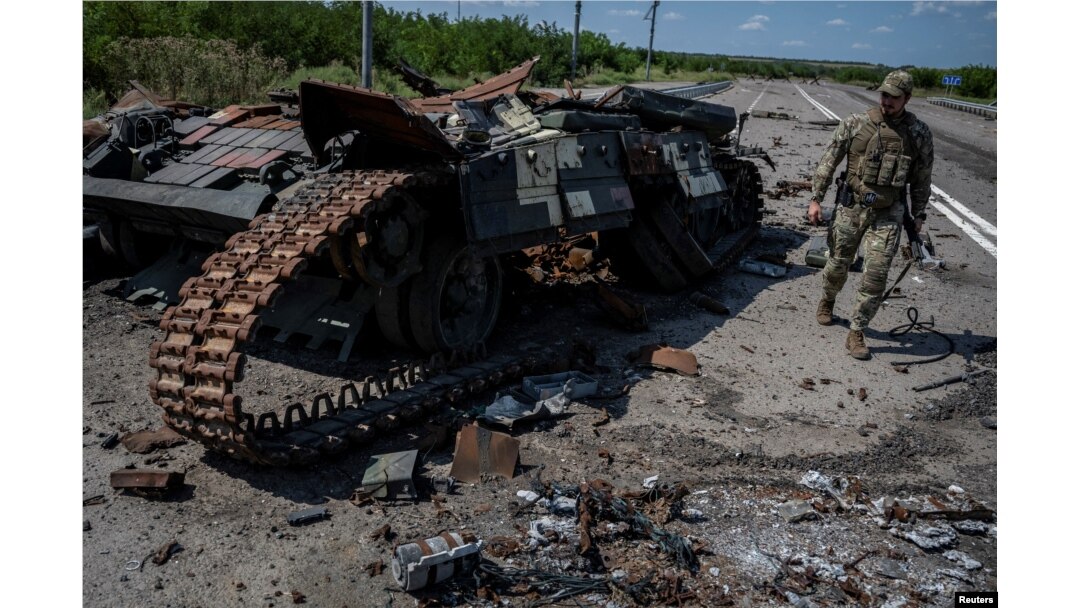 一名烏克蘭士兵在東南部羅博季涅村莊的道路上走過一輛被俄軍炸毀的坦克。(2023年8月25日)