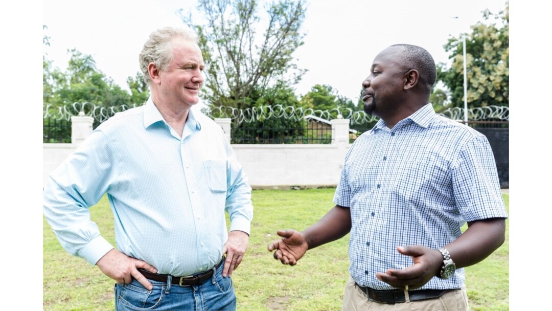 Senator Chris Van Hollen, left, walks with CARE employee while touring refugee settlements in Uganda, Aug. 14, 2019. (Photo: I. Godfrey / CARE)