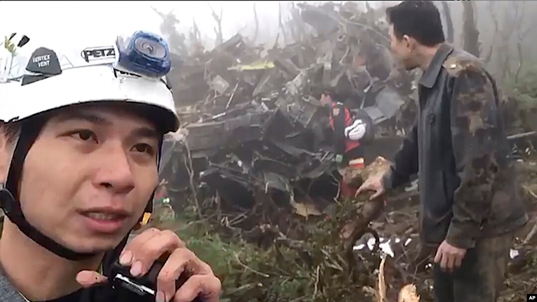 In this image made from video, emergency teams work at the crash site of a military helicopter in the mountains of Yilan, north eastern Taiwan, Jan. 2, 2020. 