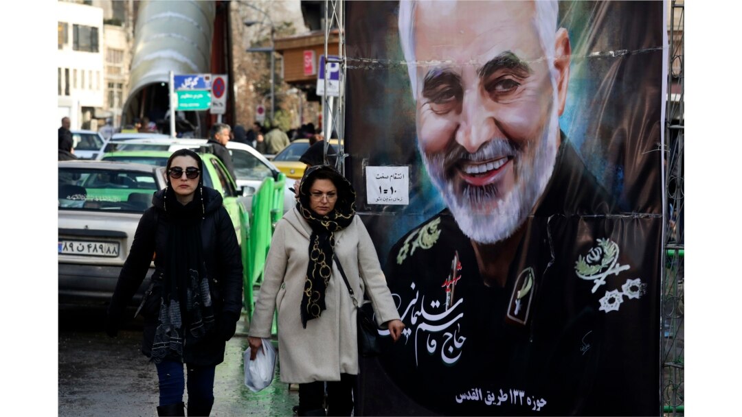 Women walk past a banner of Iranian Revolutionary Guard Gen. Qassem Soleimani, who was killed in Iraq in a U.S. drone attack Friday, in Tajrish square in northern Tehran, Iran, Jan. 9, 2020.