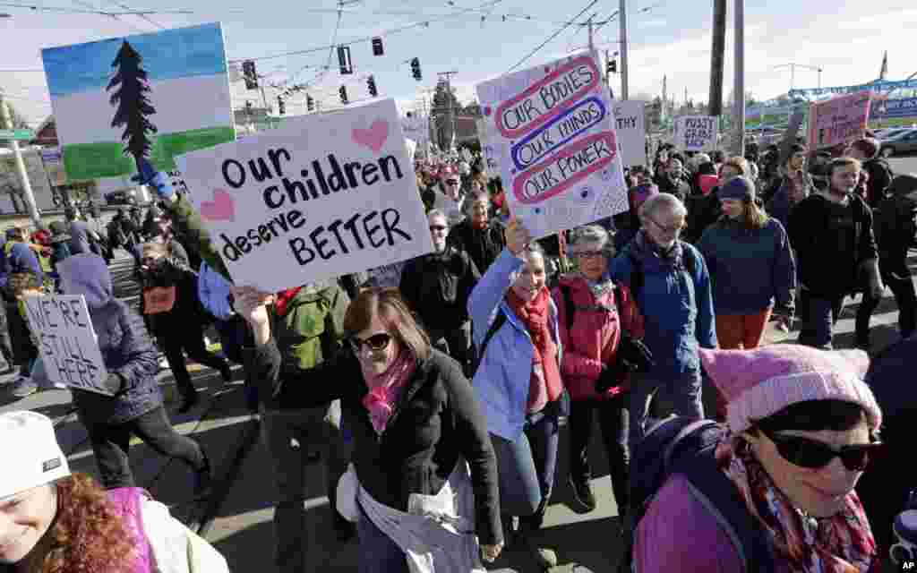 Protesters walk in a women's march that brought tens of thousands Saturday, Jan. 21, 2017, in Seattle. Women across the Pacific Northwest marched in solidarity with the Women's March on Washington and to send a message in support of women's rights and other causes. (AP Photo/Elaine Thompson)