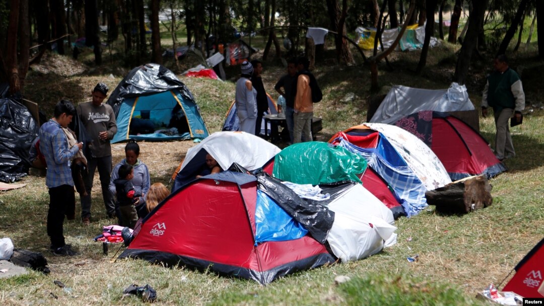 Venezuelan migrants stand at a makeshift camp near the transport terminal in Bogota, Colombia, Sept. 5, 2018. 
