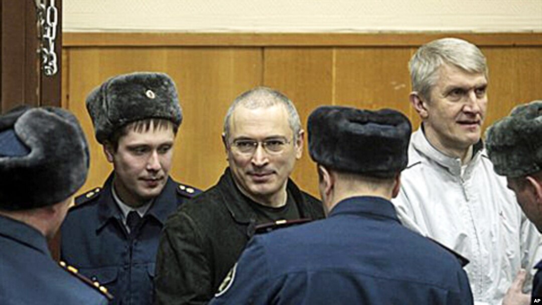 Mikhail Khodorkovsky, center, and his co-defendant Platon Lebedev, right, are escorted to a court room in Moscow, 27 Dec 2010