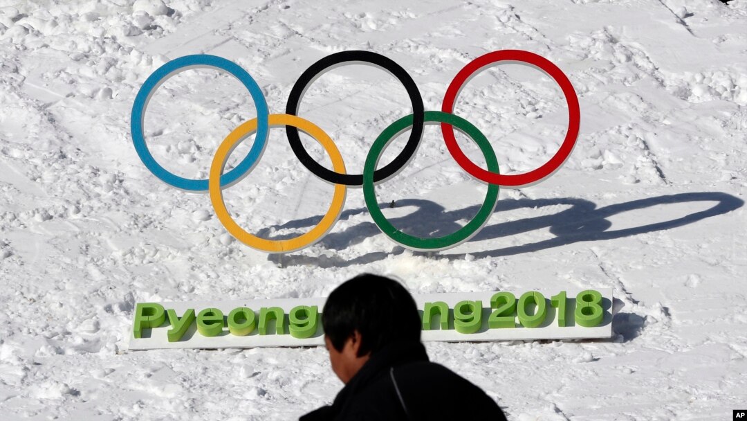 FILE - A man walks by the Olympic rings with a sign of 2018 Pyeongchang Olympic Winter Games, in Pyeongchang, South Korea, Feb. 3, 2017. 