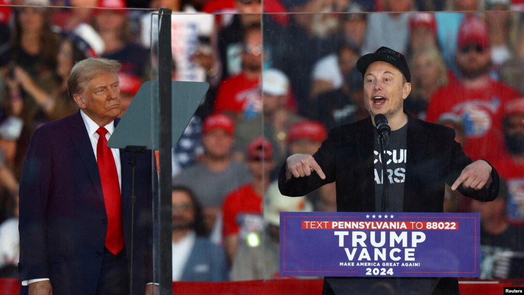 FILE - Billionaire Elon Musk speaks as Republican presidential nominee and former U.S. President Donald Trump looks on during a rally in Butler, Pennsylvania, on Oct. 5, 2024.