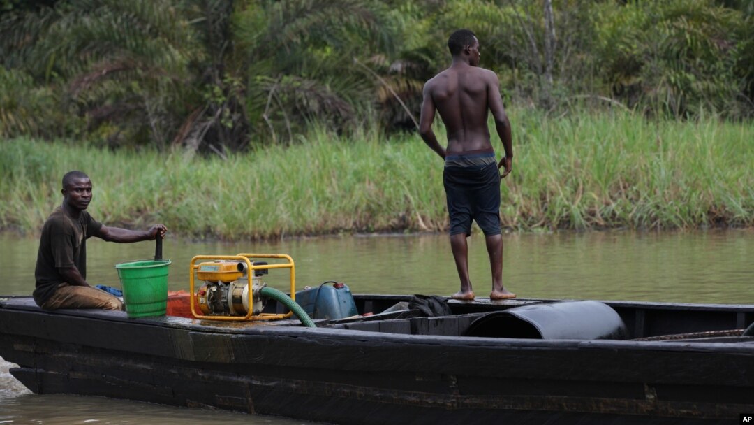 Suspected oil thieves ride a wooden boat full of stolen crude oil on the creeks of Bayelsa, Nigeria, May 18, 2013.