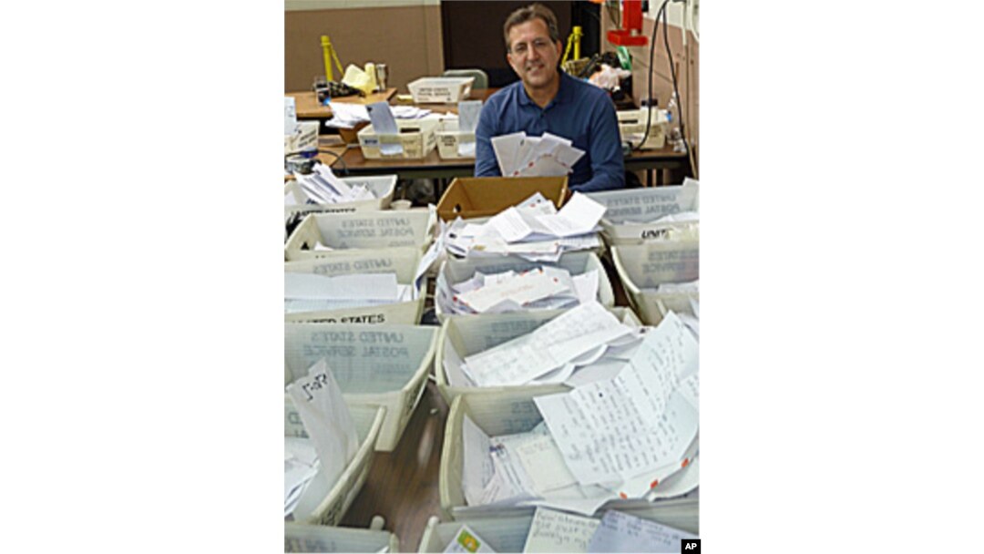 Pete Fontana, who oversees Operation Santa, amid the stacks of children's letters addressed to Santa Claus.
