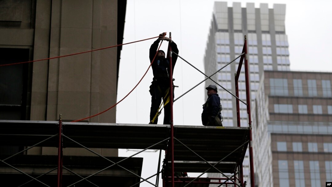 FILE- Construction workers work in midtown Manhattan in New York, Feb. 20, 2018.