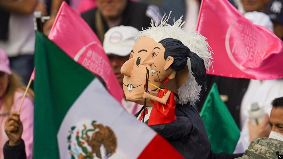 Manifestantes portan muñecos con la imagen del presidente Andrés Manuel López Obrador, y de la candidata presidencial Claudia Sheinbaum, en una marcha de organizaciones ciudadanas para exigir respeto por la autoridad electoral. El 19 de febrero en Ciudad de México.