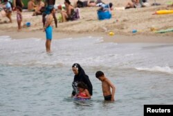 A Muslim woman wears a burkini, a swimsuit that leaves only the face, hands and feet exposed, on a beach in Marseille, France, August 17, 2016.