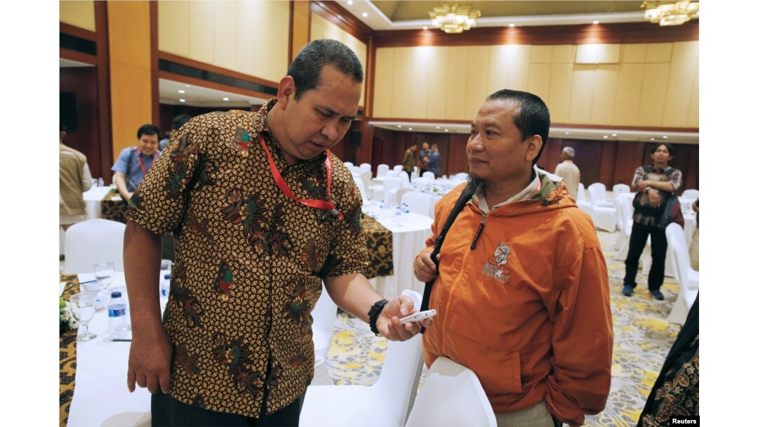 Former Indonesian militant Toni Togar, right, talks with Sarinah Jakarta bomb victim Denny Mahieu during a meeting between former militants and victims in Jakarta, Indonesia, Feb. 28, 2018.