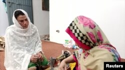 Rani Khan, a transgender woman who teaches the Koran at Pakistan's first transgender only madrasa or a religious school, looks at one of her students during a tailoring lesson in Islamabad, Pakistan March 10, 2021. Picture taken March 10, 2021. REUTERS/Sa