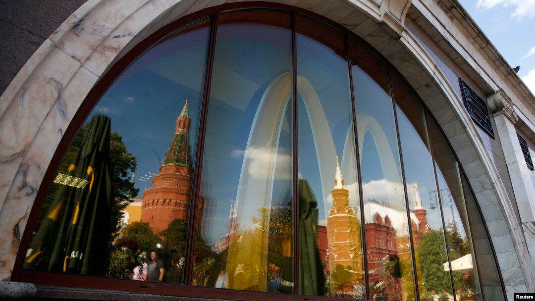 The walls and towers of the Kremlin are reflected in a window of a closed McDonald's restaurant, one of four temporarily closed by the state food safety watchdog, in Moscow, Aug. 21, 2014.