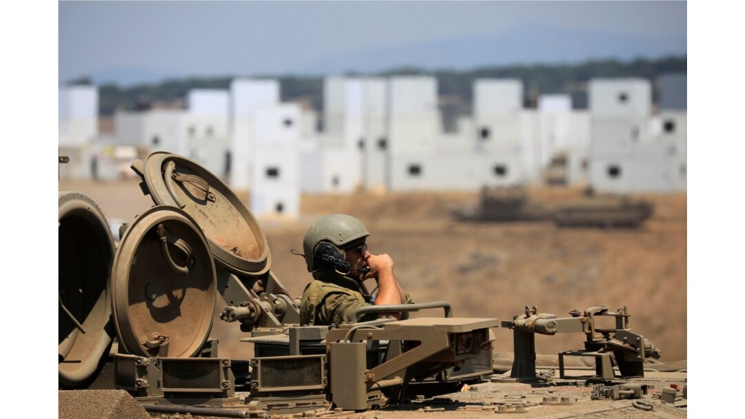 An Israeli soldier rides an armored personnel carrier (APC) as it maneuvers during in a drill at an urban warfare training base in the Israeli-controlled Golan Heights near the Israel-Syria border, Aug. 4, 2020.