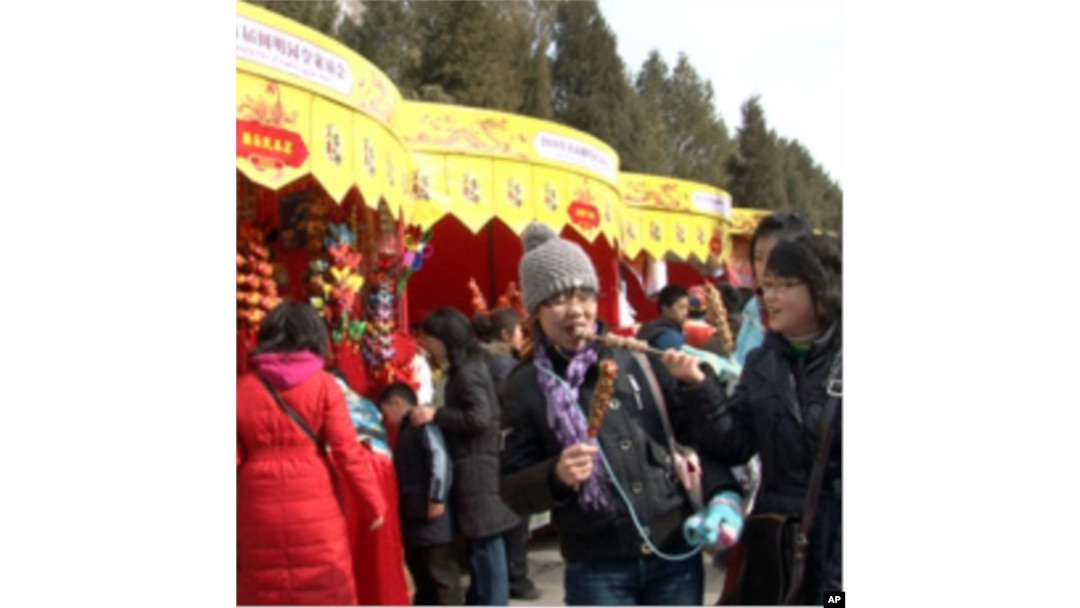 Chinese visitors enjoy snacks at this year's Spring Festival fair at the Yuanming Yuan park