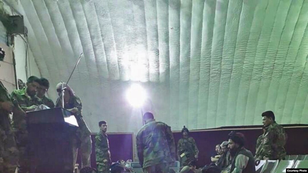 FILE - Prisoners freed from Taliban prisons in Helmand dine at an Afghan military facility. 