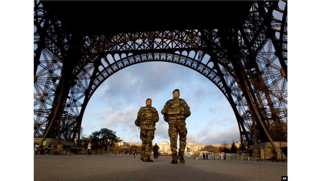French soldiers patrol at the Eiffel Tower which remained closed on the first of three days of national mourning in Paris, Nov. 15, 2015.