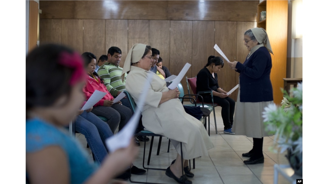 FILE - Migrants participate in a Three Kings Day Mass at the Casa del Migrante shelter run by Catholic nuns in Reynosa, Mexico, Jan. 6, 2016.
