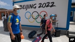 2022年冬季奧運會一年後將在北京舉行，目前，超過180個機構呼籲各國政府抵制這場賽事。圖為到河北省張家口崇禮的遊客走過北京2022冬季奧運會的廣告牌。（美聯社2020年8月13日資料照）