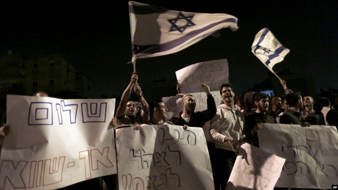 Israelis hold signs and flags as they protest the cease-fire in the southern Israeli city of Kiryat Malachi, Wednesday, Nov. 21, 2012.