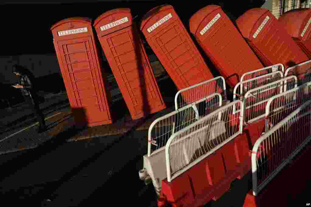 The sun shines on part of "Out of Order," a 1989 red phone box sculpture by British artist David Mach in Kingston upon Thames, south west London, Sept. 11, 2017.