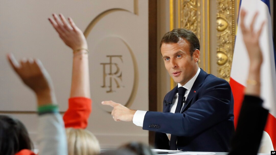 Members of the media raise their hands as French President Emmanuel Macron answering questions during a media conference at the Elysee Palace, April 25, 2019 in Paris.