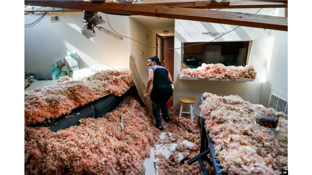 Erica Bohannon leads reporters through her destroyed apartment, May 28, 2019, in Trotwood, Ohio, after a tornado storm system passed through the area the night before, tearing her roof off while she huddled with her son and dog in her bedroom closet.